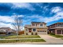 Charming two-story house with a stone facade, a well-manicured lawn, and a paved driveway at 20305 E 41St Ave, Denver, CO 80249