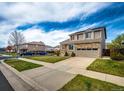 Two-story home with a stone facade, a paved driveway, and solar panels at 20305 E 41St Ave, Denver, CO 80249