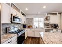 Bright kitchen with stainless steel appliances, granite counters and brick backsplash at 1786 Quartz St, Castle Rock, CO 80109