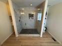 Large glass shower featuring dual shower heads, recessed lighting, and marble tiling at 1786 Quartz St, Castle Rock, CO 80109