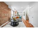 Bright living room featuring exposed brick wall, hardwood floors, and modern decor at 3028 N Gilpin St, Denver, CO 80205