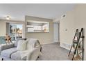 Inviting living room with view to kitchen, a sliding glass door, and modern furnishings at 5706 W Asbury Pl # 205, Lakewood, CO 80227