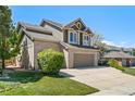 Charming two-story home featuring a brick and siding facade, a three-car garage, and mature landscaping at 8833 Maplewood Dr, Highlands Ranch, CO 80126