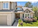 Inviting front entrance featuring a beautiful wood door with glass panels and manicured landscaping at 8833 Maplewood Dr, Highlands Ranch, CO 80126