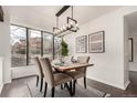 Elegant dining room with a modern light fixture and large windows overlooking the outdoors at 9400 E Iliff Ave # 103, Denver, CO 80231