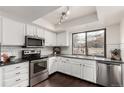 Well-lit kitchen featuring white cabinetry, stainless steel appliances, and dark countertops at 9400 E Iliff Ave # 103, Denver, CO 80231