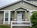 Inviting home exterior featuring a light green color, brick accents and bright white trim at 14400 Albrook Dr # 88, Denver, CO 80239