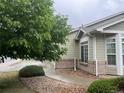 Landscaped front yard with green bushes and a stone pathway leading to the house at 14400 Albrook Dr # 88, Denver, CO 80239