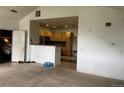 Open living room with tan carpet flowing into the adjacent kitchen with wood cabinets at 14400 Albrook Dr # 88, Denver, CO 80239