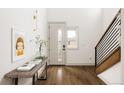 Inviting entryway featuring light walls, a modern console table, and sleek wood floors at 2020 Teller St, Lakewood, CO 80214