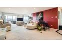 Open living room with plush seating, piano, and cityscape view from large balcony doors at 7865 E Mississippi Ave # 1501, Denver, CO 80247