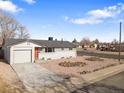 View of charming single-story home with a spacious driveway and xeriscaped front yard on a sunny day at 306 N 14Th Ave, Brighton, CO 80601