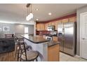 Kitchen with stainless steel appliances and an island with seating at 11844 Oak Hill Way # A, Commerce City, CO 80640