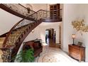 Grand foyer with a curved staircase, elegant decor, and natural light at 8002 Galileo Way, Littleton, CO 80125