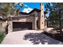 A beautiful stone home featuring a two-car garage and a long driveway at 8002 Galileo Way, Littleton, CO 80125