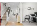 Bright entryway featuring hardwood floors, a staircase, and a view into the living room, creating an inviting atmosphere at 12491 E 106Th Pl, Commerce City, CO 80022