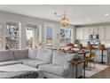 Spacious living room with large windows, a sectional sofa, and an open layout to the kitchen at 199 Simmental Loop, Castle Rock, CO 80104