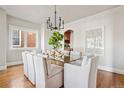 Elegant dining room features a modern chandelier, glass table, and seating for eight at 1215 S Ogden St, Denver, CO 80210