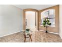 Inviting entryway featuring tile flooring, arched openings, and a view of the staircase and upper level at 9735 E 112Th Pl, Commerce City, CO 80640