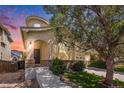 Charming stucco home with arched entry, large windows, mature trees, and well-manicured lawn in a desirable neighborhood at sunset at 9735 E 112Th Pl, Commerce City, CO 80640