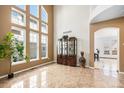 Open living room featuring soaring windows, high ceilings, tile flooring, and stylish display cabinet at 9735 E 112Th Pl, Commerce City, CO 80640