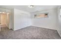 Cozy bedroom with neutral carpet, white walls, closet, and a bright window at 1303 Havana St, Aurora, CO 80010