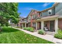 Beautifully landscaped townhomes with brick and neutral siding, plus a well-manicured lawn at 767 Roslyn St # 20, Denver, CO 80230