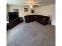 Large living room features a comfortable brown sectional, neutral carpeting, and decorative wall art at 47314 Iris Ave, Bennett, CO 80102