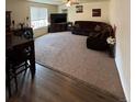 Spacious living room featuring plush carpeting, a ceiling fan, and a comfortable, large sectional sofa at 47314 Iris Ave, Bennett, CO 80102
