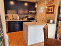 Well-lit kitchen with dark cabinets, granite countertops, stainless steel appliances and wooden floor at 1778 S Lee St, Lakewood, CO 80232