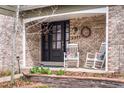 Cozy front porch with brick detailing, rocking chairs, and decorative wreath at 5951 E Irish Pl, Centennial, CO 80112