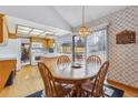 Dining area with wooden table and chairs adjacent to the kitchen, bright with natural light at 8836 E Phillips Pl, Centennial, CO 80112