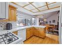 Cozy kitchen featuring wooden cabinets and hardwood floors adjacent to dining area at 8836 E Phillips Pl, Centennial, CO 80112