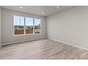 Bright living room with large window showcasing neighborhood views and wood-look floors at 9468 W 58Th Ln # C, Arvada, CO 80002