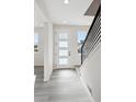 Bright entryway featuring modern white door with frosted glass and sleek black railing at 1269 Penner Dr, Erie, CO 80026