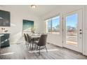 Bright dining area with a modern table set, large windows, and a door leading to the outdoor space at 15336 W 68Th Loop, Arvada, CO 80007