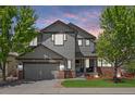 Charming two-story home featuring gray siding, brick accents, a well-manicured lawn, and mature shade trees at 4467 Trailside Ln, Castle Rock, CO 80109