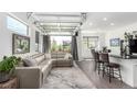Open-concept living room with a unique glass garage door ceiling and stylish contemporary furnishings at 6396 Nelson Ct, Arvada, CO 80004
