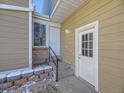 View of townhouse side entrance with brick steps and exterior storage at 11860 Harrison St, Thornton, CO 80233