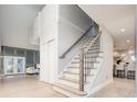 Bright foyer with hardwood floors, open staircase, and views into the living room and kitchen at 7743 S Jersey Way, Centennial, CO 80112