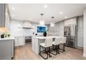 Modern kitchen with white cabinets, stainless steel appliances, quartz countertops and island with seating at 7743 S Jersey Way, Centennial, CO 80112