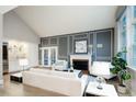 Elegant living room with a fireplace, custom wall paneling, and view into the dining area at 7743 S Jersey Way, Centennial, CO 80112