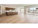 Open kitchen with large island, wooden cabinets, stainless steel appliances, and hardwood floors throughout at 483 Agoseris Way, Castle Rock, CO 80104