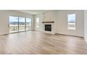 Bright living room features sleek hardwood floors, a modern fireplace, and sliding glass doors to the balcony at 483 Agoseris Way, Castle Rock, CO 80104