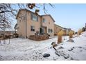 Landscaped backyard with a stone retaining wall and snowy ground at 17395 Leisure Lake Dr, Monument, CO 80132