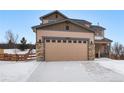 Two-story house with a beige exterior, stone accents, and a three-car garage at 17395 Leisure Lake Dr, Monument, CO 80132