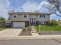 Charming two-story home with a well-manicured lawn, gray siding, and inviting front entrance at 1488 W 102Nd Ave, Northglenn, CO 80260
