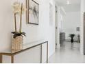 Modern hallway with sleek console table, white walls, and neutral tile flooring at 1201 N Williams St # 3A, Denver, CO 80218