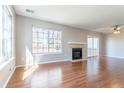 Bright living room featuring a fireplace, large windows providing plenty of natural light, and wood flooring at 12743 Eudora Dr, Thornton, CO 80241