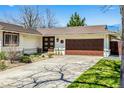 Charming single-story home with well-manicured front yard, brown roof, and an attached two-car garage at 6963 E Heritage S Pl, Centennial, CO 80111